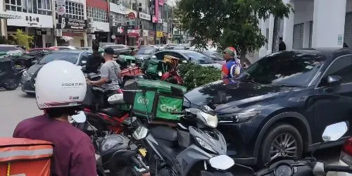 Large group of Grab riders crowd outside Oriental Kopi Puchong, causing traffic buildup - amirul.nin
