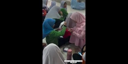 Woman demonstrates proper pad use and disposal while teaching girls about menstruation - iwanaaisyah