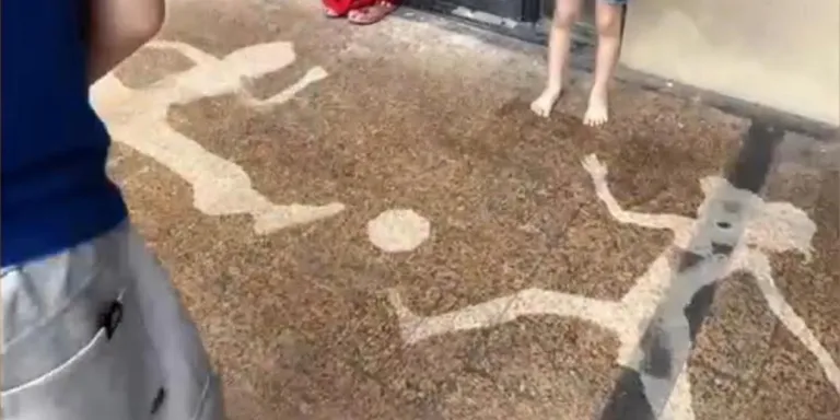 Father and daughters create football shadow art with spray bottle and bucket